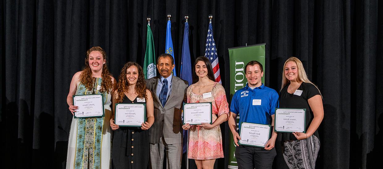 Students receiving scholarship from President Ramsammy